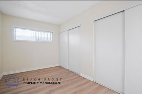 A room with a window and a logo for Beach Front Property Management.