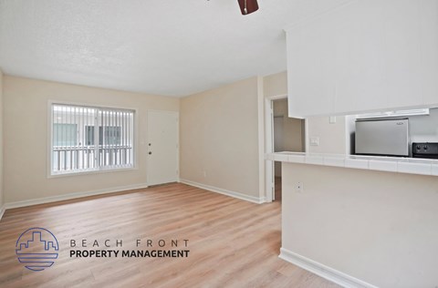 A room with a window and a microwave on the counter.