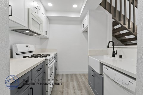 A modern kitchen with white cabinets and appliances.