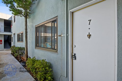 A white door with a gold handle and a number 7 above it.