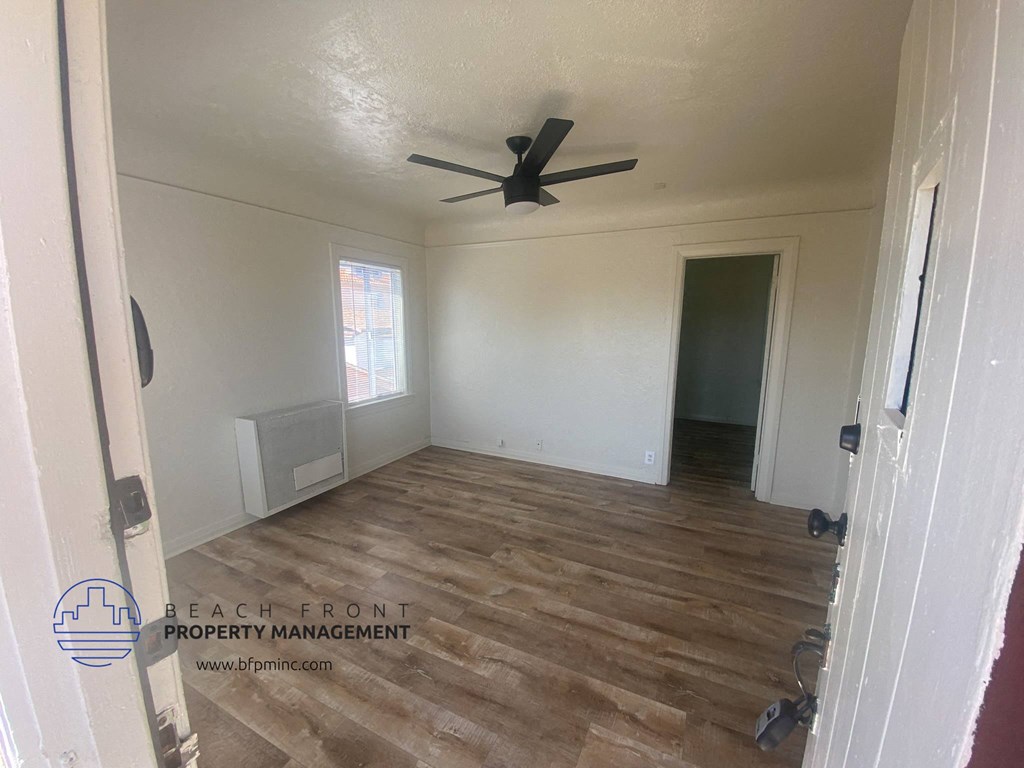 a living room with a ceiling fan and wood floors