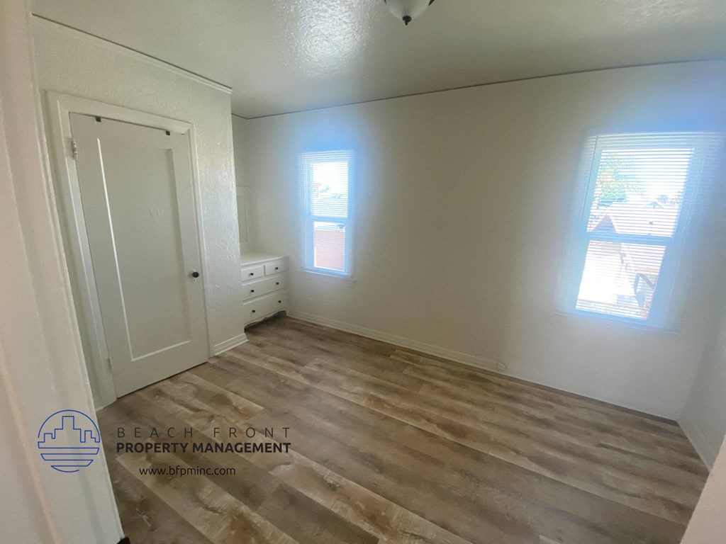 the living room of a house with white walls and wood floors