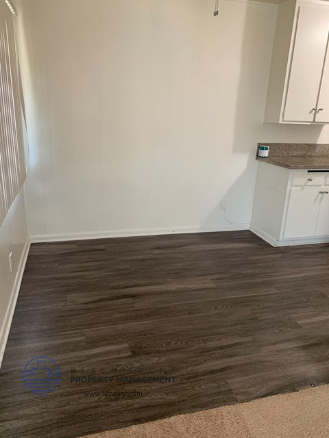 a living room with wood flooring and white walls and a counter