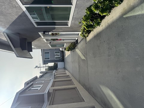 A modern building with a grey exterior and a green plant on the top.