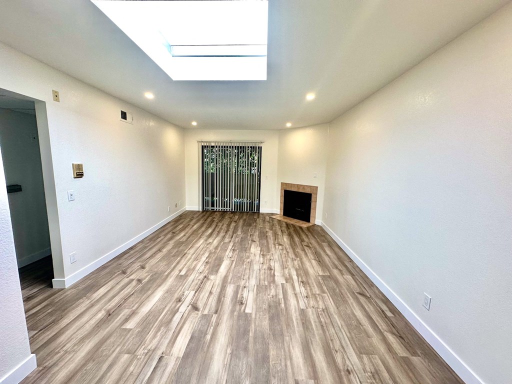 the living room of a new home with wood flooring and a fireplace