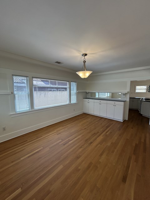 A room with wooden floors and a ceiling fan.