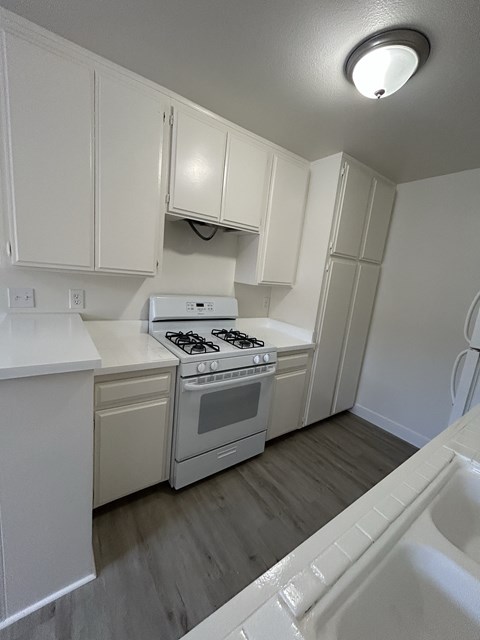 A white kitchen with a stove and oven.