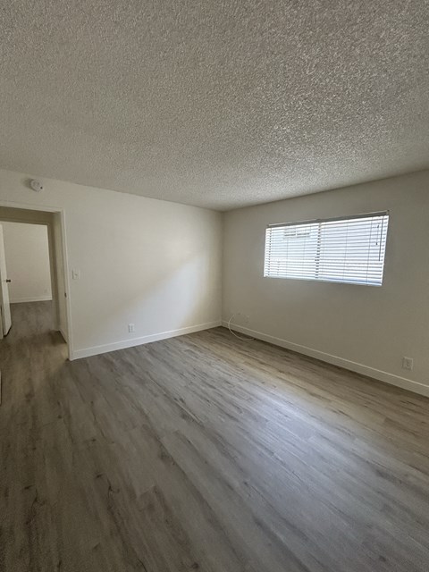 A room with a window and wooden flooring.
