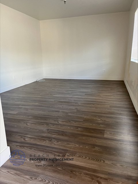 an empty room with hardwood flooring in a house
