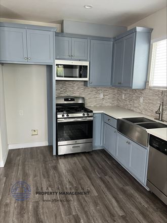 a kitchen with blue cabinets and stainless steel appliances