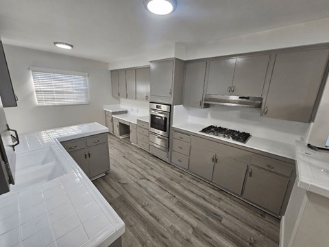 a kitchen with gray cabinets and white countertops
