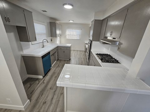 a kitchen with white countertops and gray cabinets