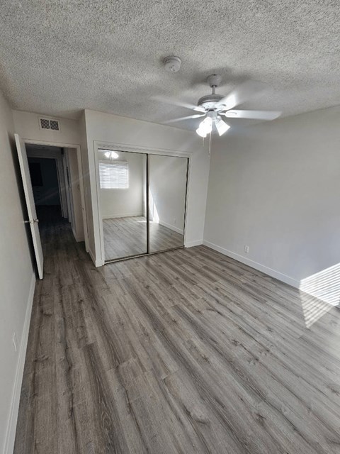 an empty living room with a ceiling fan