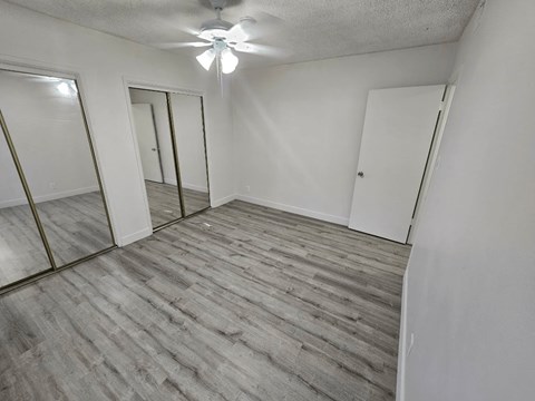 an empty bedroom with a ceiling fan