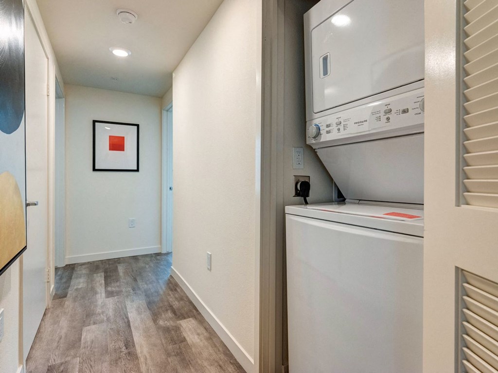 a laundry room with a washer and dryer and a door to a closet