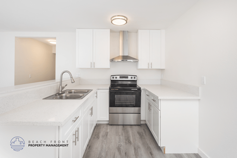A modern kitchen with white cabinets and stainless steel appliances.