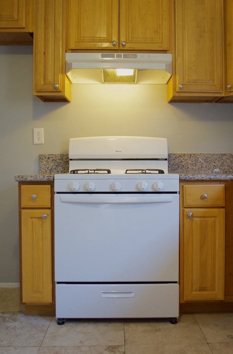 a white stove top oven in a kitchen with wooden cabinets