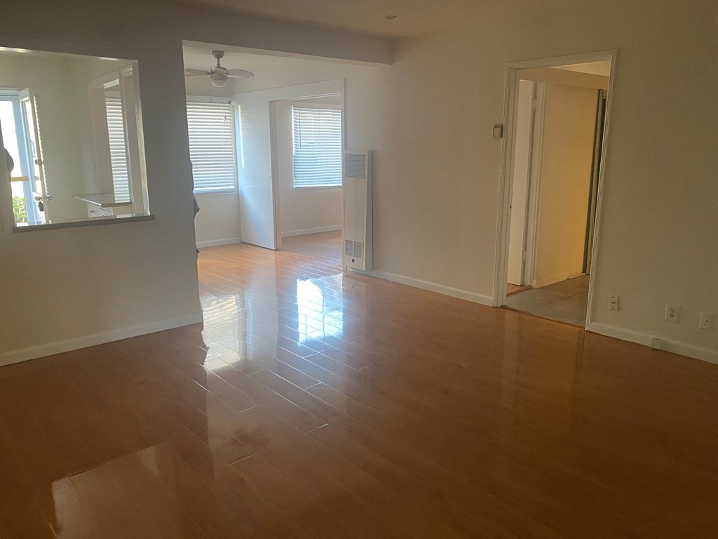 an empty living room with a hard wood floor