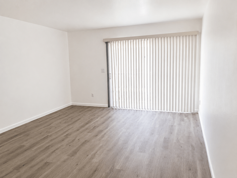 A room with a sliding door and wooden flooring.