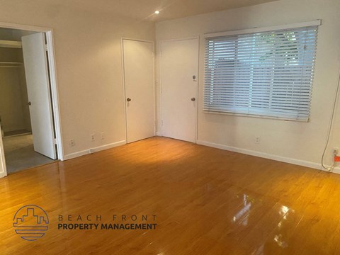 a living room with wood floors and a window and a door