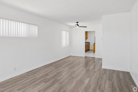 A room with a ceiling fan and wooden flooring.
