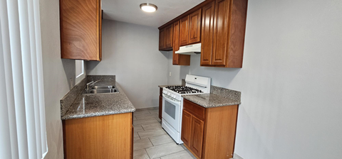 a kitchen with wooden cabinets and a stove and a sink