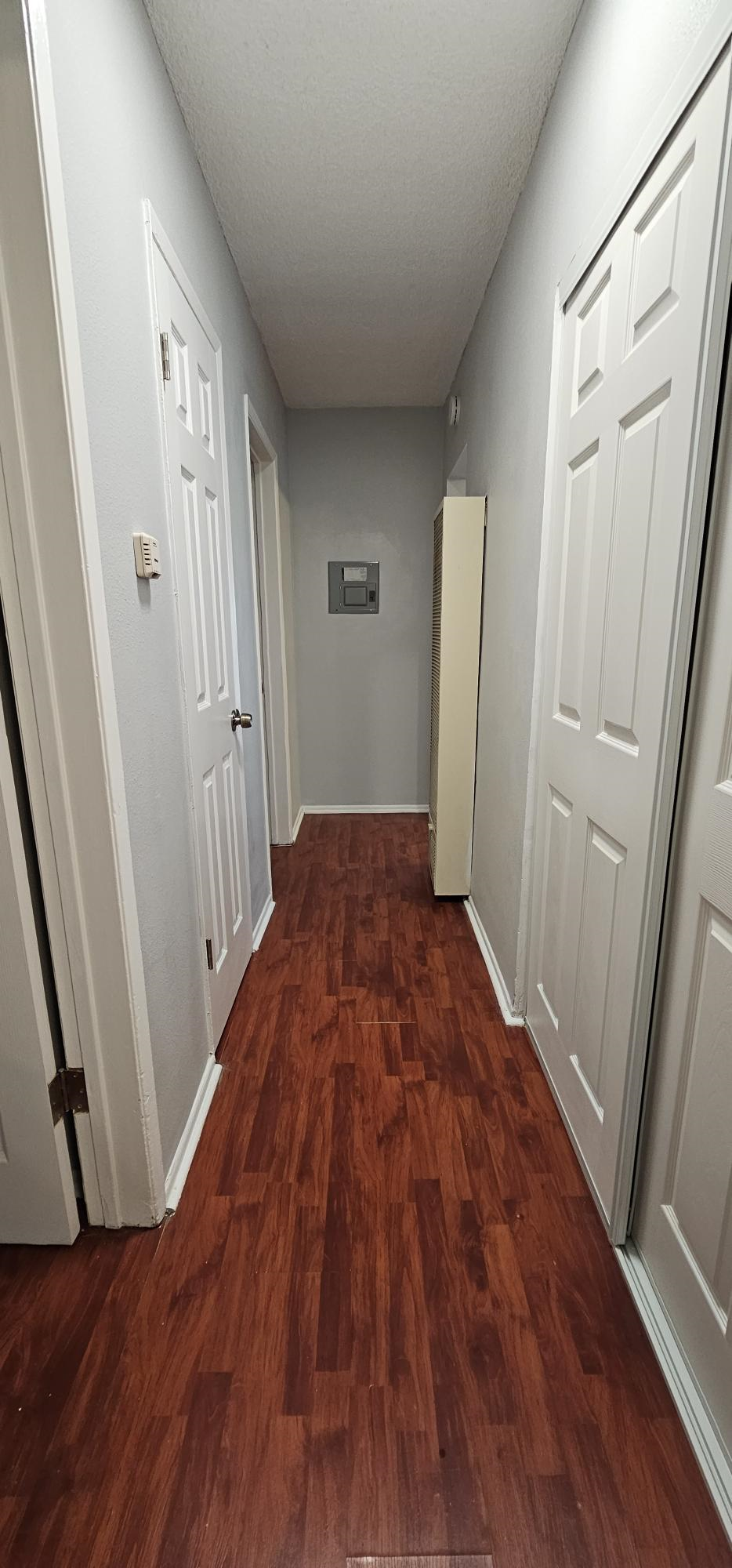 a hallway with wood flooring and white doors