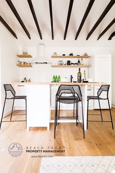 a kitchen with white cabinets and black and white bar stools
