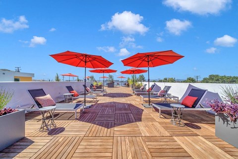 a deck with red umbrellas on top of a roof