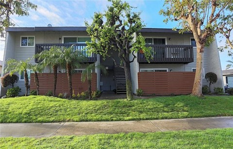 A two-story apartment building with a balcony on the second floor.