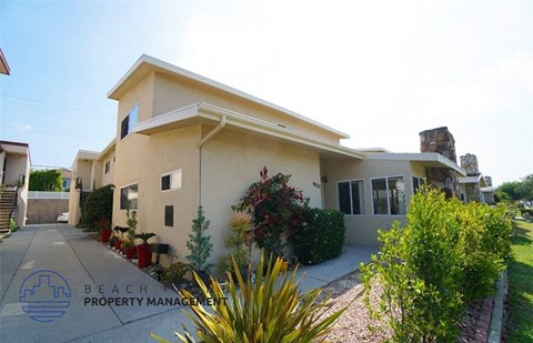 A house with a driveway and landscaping in front of it.