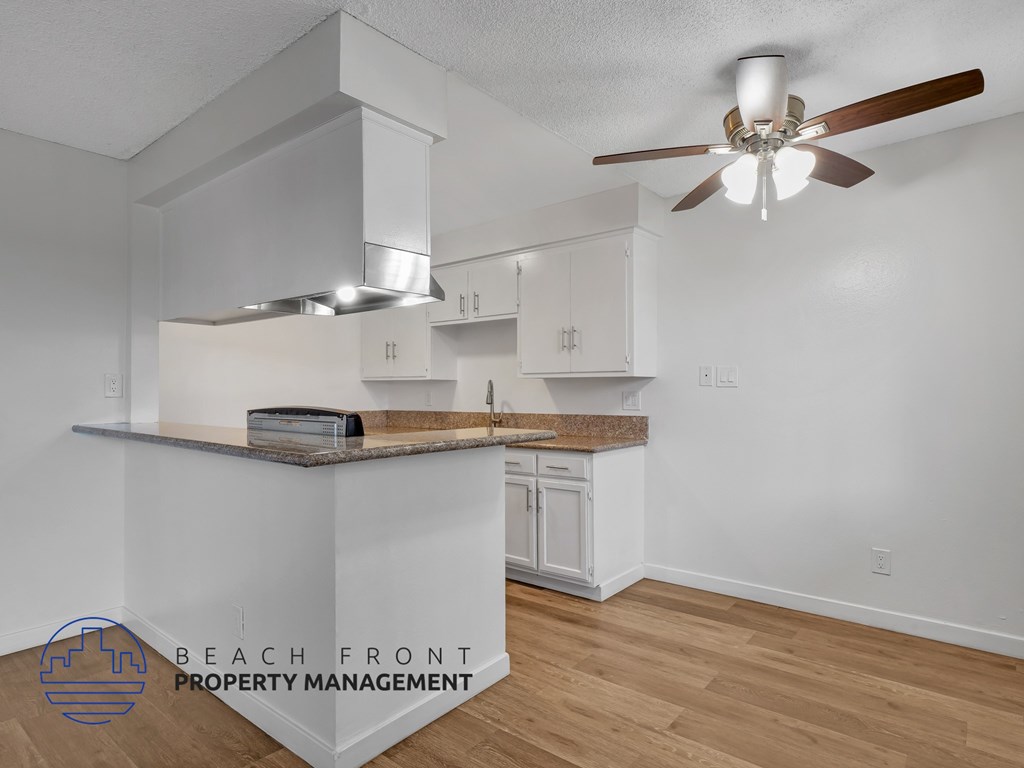 A kitchen with a counter top and a fan.