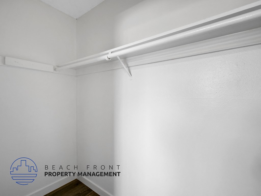A white wall with a logo for Beach Front Property Management.
