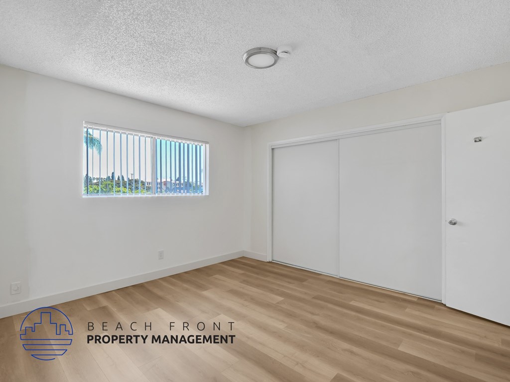 A room with a window overlooking the beach.