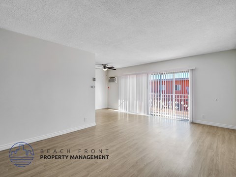 A spacious room with a ceiling fan and sliding glass doors.