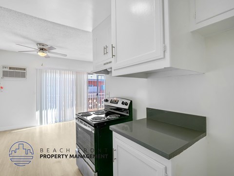A kitchen with a stove and a fan on the ceiling.