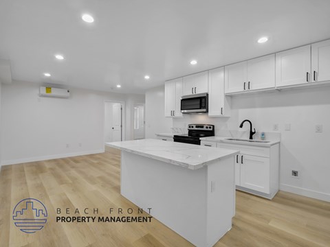 A kitchen with white cabinets and a countertop with a microwave and toaster oven on it.