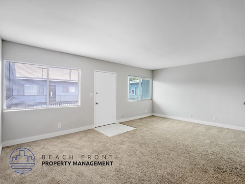 A room with a carpeted floor and a window with blinds.