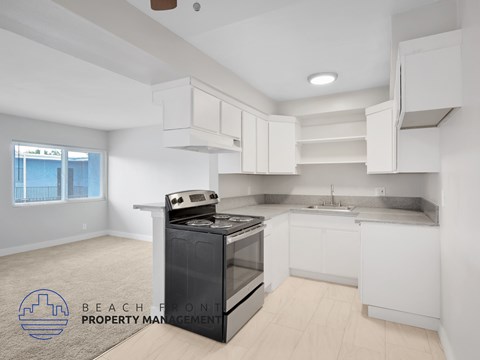 A kitchen with white cabinets and a black stove top oven.