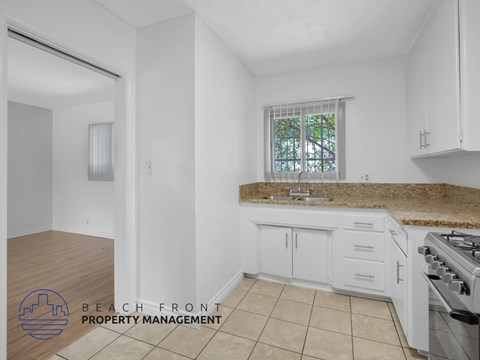 A kitchen with white cabinets and a granite countertop.
