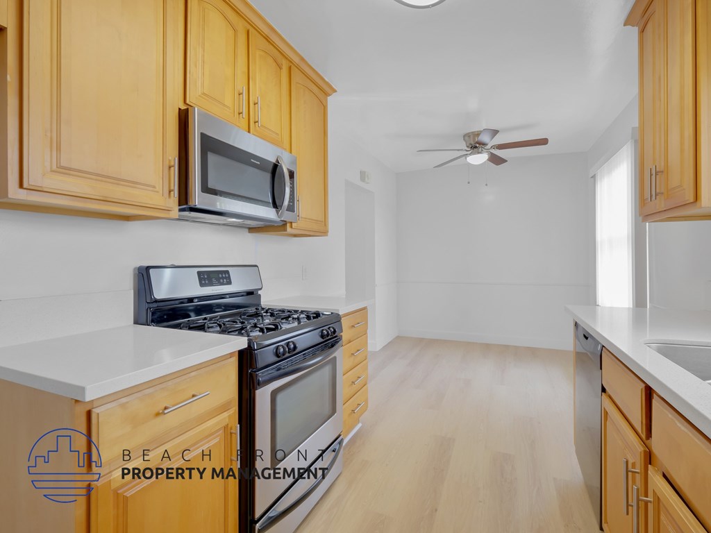A kitchen with wooden cabinets and a stove top oven.