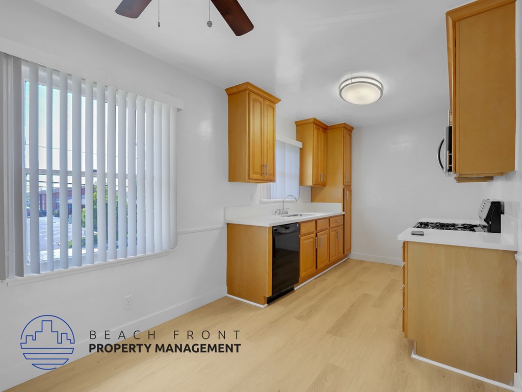 A kitchen with wooden cabinets and a stove top oven.
