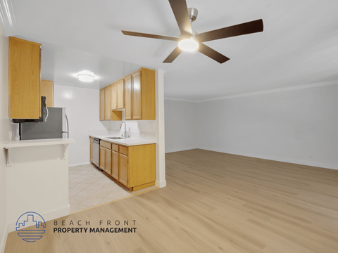 A spacious room with wooden flooring and a ceiling fan.