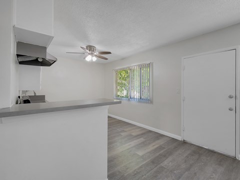 A room with a ceiling fan and a window with blinds.