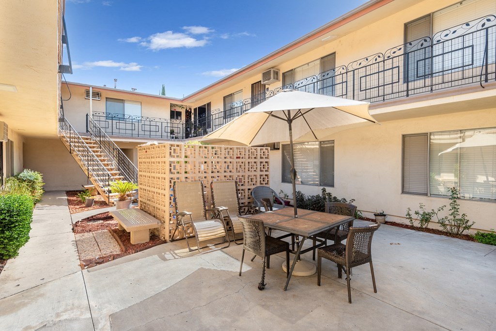 a patio with a table and chairs and an umbrella