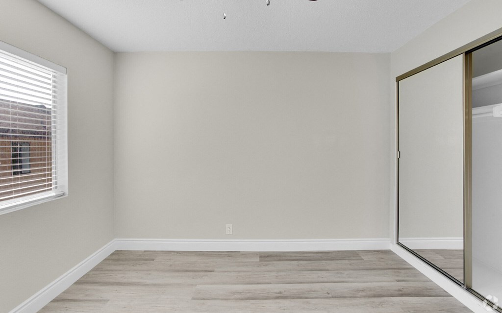 an empty room with a sliding glass door and a window