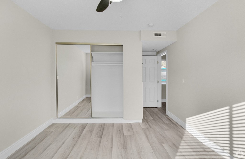 a renovated living room with white walls and a sliding glass door