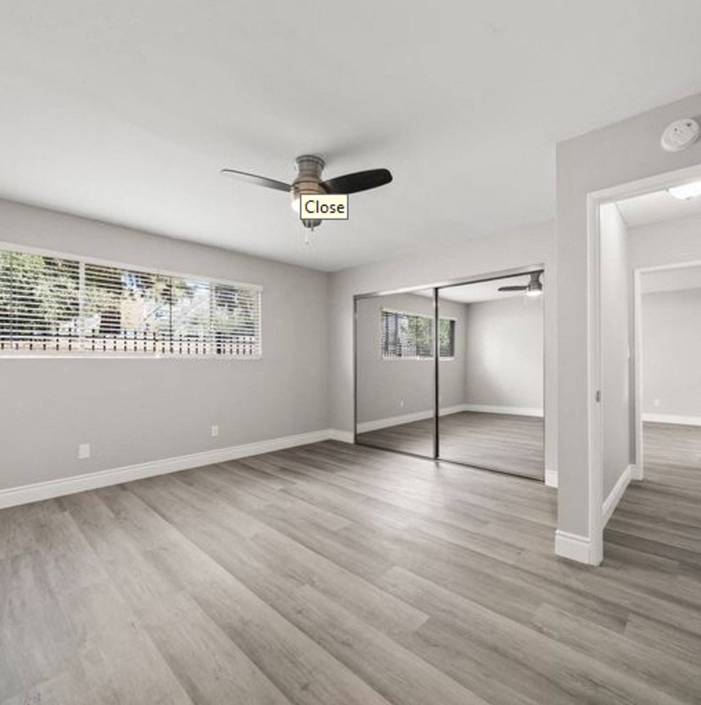 the living room and dining room of a house with a ceiling fan