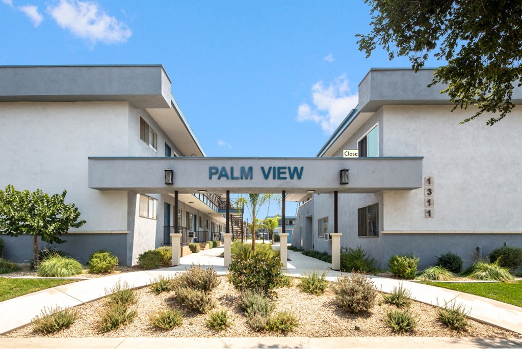 a white building with a sign that reads palm view