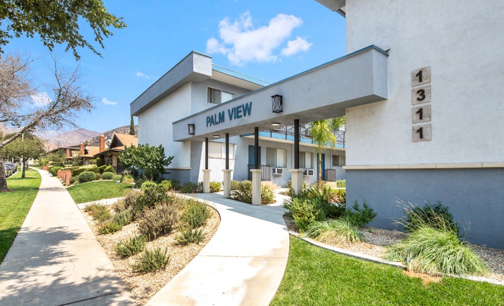 a white building with a sign that says nu view on it and a sidewalk